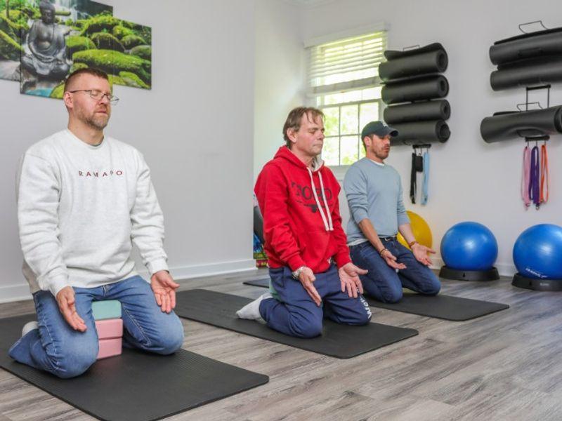 Clients practicing yoga and meditation on mats at Rolling Hills Recovery Center.