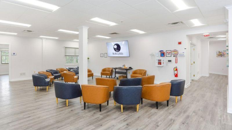 Group therapy room at Rolling Hills Recovery Center with arranged chairs, TV screen, and bright modern space.