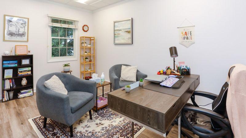 Therapist office at Rolling Hills Recovery Center with desk, gray chairs, bookshelves, and cozy décor.