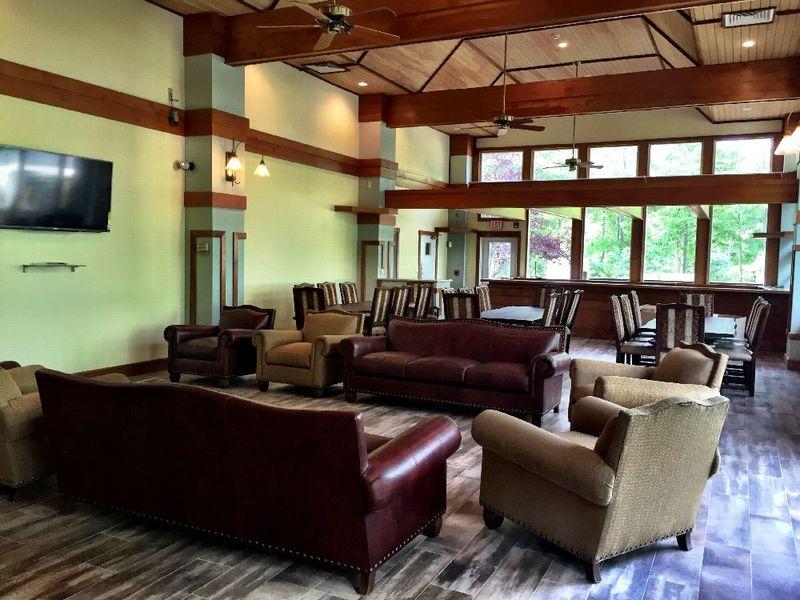 Enlightened Solutions living room/dining room is furnished with big leather couches and long wooden family style tables. The lighting and sound of the fountains on the walls provide a peaceful and comfortable atmosphere.