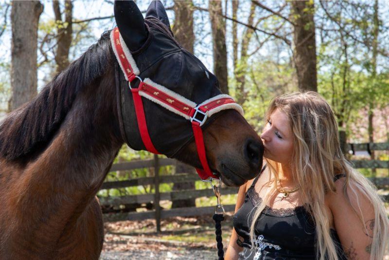 Client at Rolling Hills Recovery Center interacting with a horse during equine therapy outdoors.