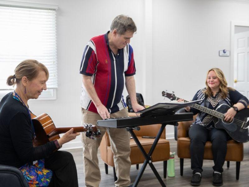 Music therapy session with clients playing guitar and keyboard at Rolling Hills Recovery Center.